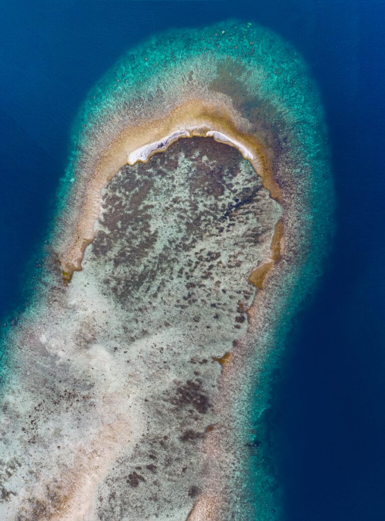 Stunning drone shot of a coral reef in Kepulauan Seribu, Indonesia, showcasing turquoise waters.